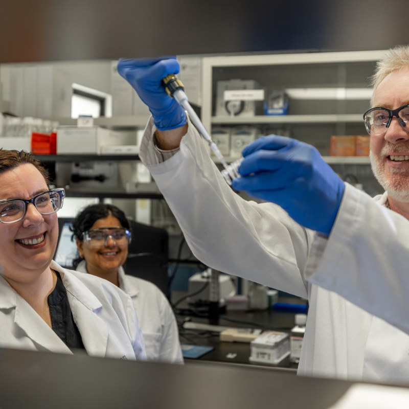 Photo of people looking at a beaker